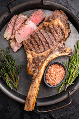 Roasted Tomahawk beef steak, roast dry aged rib eye with bone. black background. top view