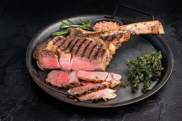 Roasted Tomahawk beef steak, roast dry aged rib eye with bone. black background. top view
