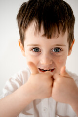 portrait of a little boy on a white background in close-up with blue eyes