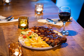Tender grilled porterhouse or t-bone steak served with crisp golden French fries and fresh green herb salad accompanied by a BBQ or tomato ketchup sauce