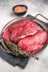 Uncooked beef cheeks, raw meat in steel tray. grey background. top view