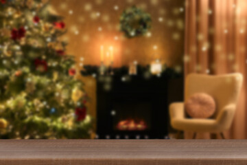 Empty wooden table against blurred room with Christmas tree, bokeh lights. Space for design