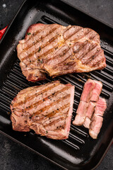 Fried on grill skillet pork tender steak, neck meat. black background. top view