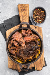 Red Wine Braised Beef Cheek meat with Creamy sauce in a skillet. grey background. top view