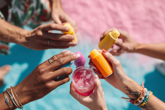Friends toasting with colorful drinks and tonics. Vibrant summer colors, playful vibe. Perfect for wellness, lifestyle, and friendship themes. Optimistic - Powered by Adobe