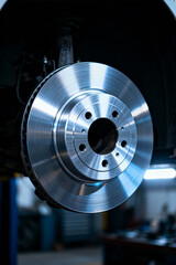 Rotating brake disc shown in automotive service facility during routine maintenance on a vehicle