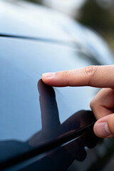 Inspecting a scratch on a car's surface during automotive service