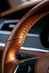 Close-up view of a premium leather steering wheel with stitching in a modern vehicle interior