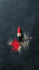 A single red lipstick tube is positioned on a dark, textured surface, with a vibrant red smear and scattered powder beside it.