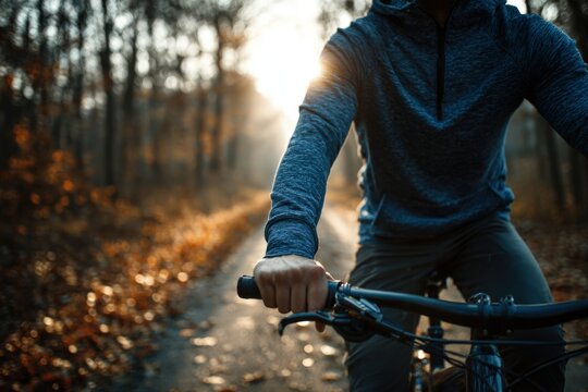 Athletic Man Cycling on Autumn Forest Road in Blue Top