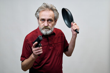 Older man with wrinkles on face skin posing as aggressor in studio