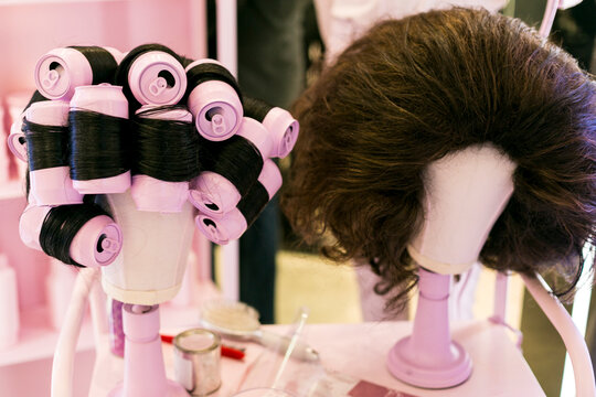 New York City, NY, USA. Wigs and pink rollers on head stand mannequins. 