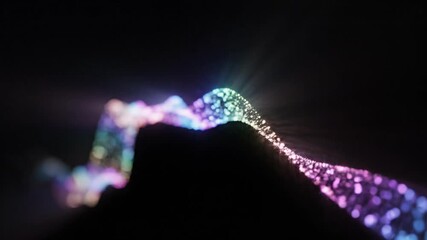 Abstract glowing particles form a flowing wave. A colorful digital DNA helix structure on a black background. Technology and data visualization concept - Powered by Adobe