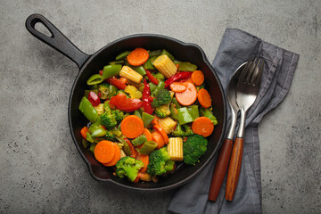 Colorful vegetables broccoli carrot green beans bell pepper stir fried in a cast iron skillet, presenting a healthy and fresh vegetarian meal