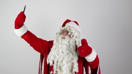 Santa Claus is taking a Christmas selfie with his smartphone