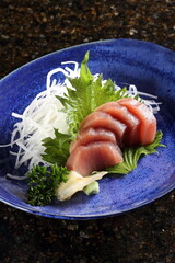 Tuna sashimi with greens on a plate