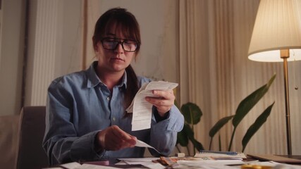 Businesswoman at home office using a calculator to check the company's budget, invoices, or expenses. High quality 4k footage