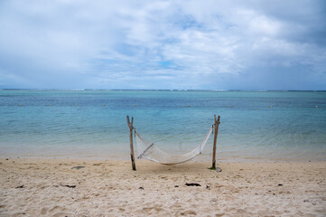 Idyllic wallpaper of a hammock on a tropical island among palm trees at sunset
