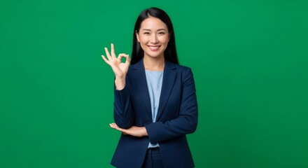 A woman in a business suit showing an okay sign. Ok symbol, successful gesture. Expressing approval on green screen background.