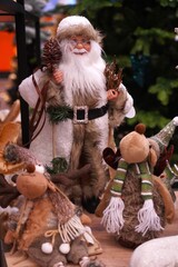 vintage figure of santa claus in brown fur coat with plush vintage reindeer on new year background in house as holiday winter concept