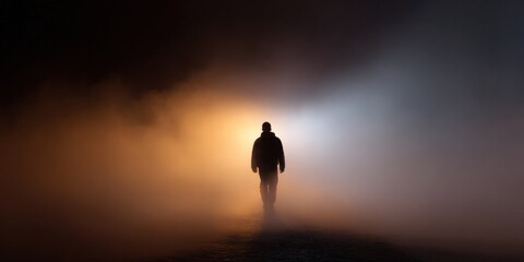 Silhouetted figure walking through foggy mist at night
