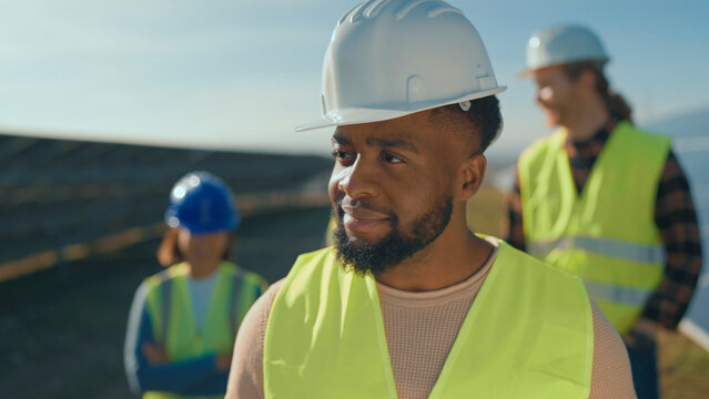 Group of construction workers assessing site conditions under clear blue sky during the day