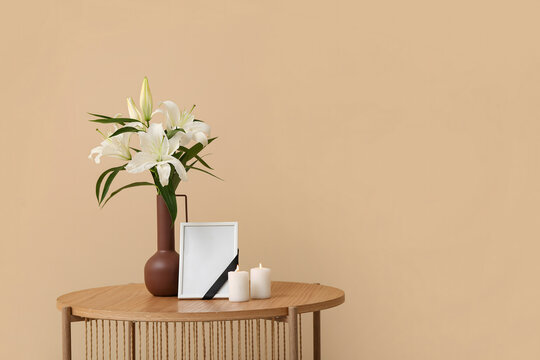 Elegant lilies and candles beside framed memory create a heartfelt sympathy expression, perfect for remembrance and memorial tributes with soft lighting.