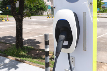 Electric vehicle charging station in outdoor parking lot on a sunny day. Eco-friendly transportation concept.