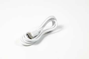 New white USB type charger cable in pack, compatible for many devices, wrapped in a spiral shape, isolated on white background.