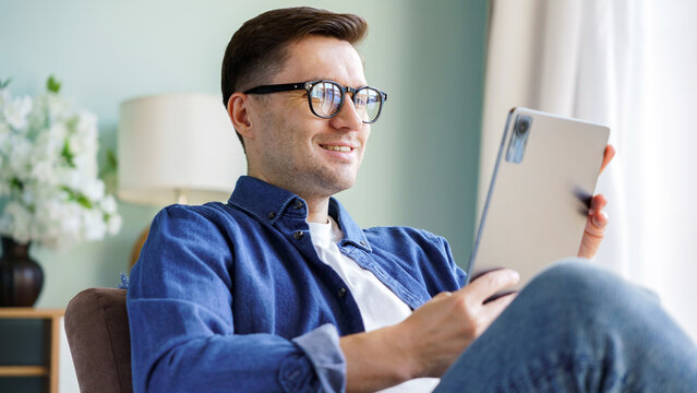 Young man using tablet while relaxing at home