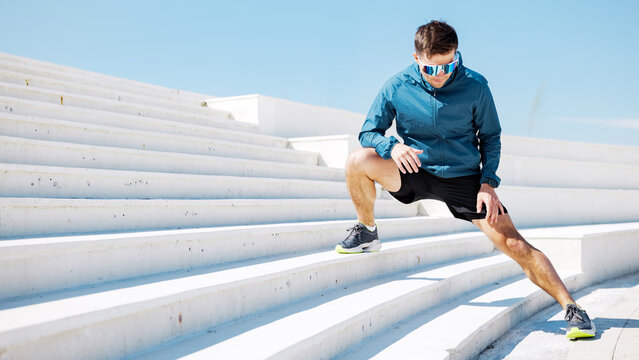 Runner stretches on outdoor steps during exercise session