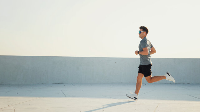 Man runs along a flat surface in casual athletic wear