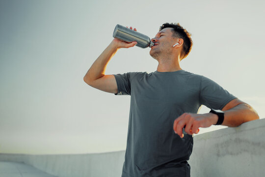 Man hydrates while enjoying outdoor exercise session