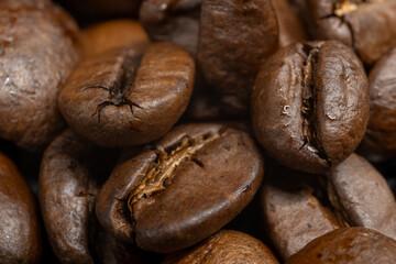 Macro close-up image of roasted coffee beans showing detailed texture and rich brown color