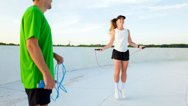 Couple enjoys skipping rope workout on a sunny day