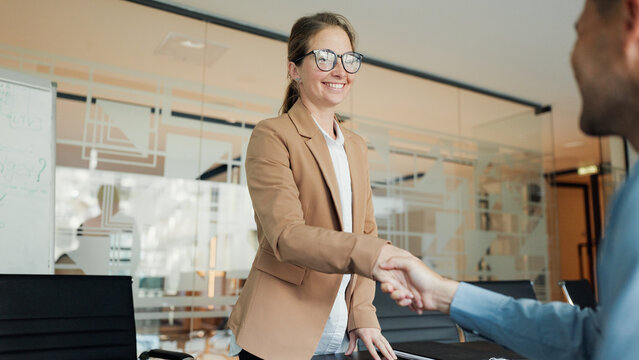 Business professionals shake hands in a modern office