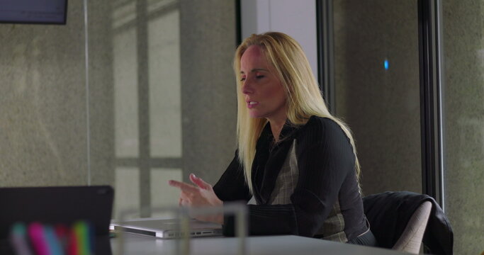 Business woman seated at desk in quiet contemplation, appearing pensive and exasperated while showing early signs of burnout during stressful work day in modern office