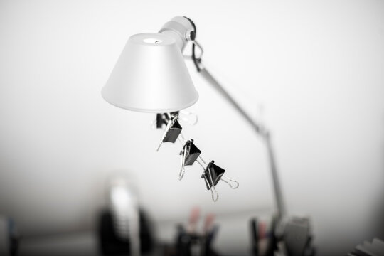Desk lamp with paper clips hanging under neath the lamp shade