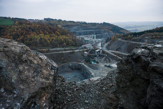 Open pit mine in the fall with yellowing trees in the distance