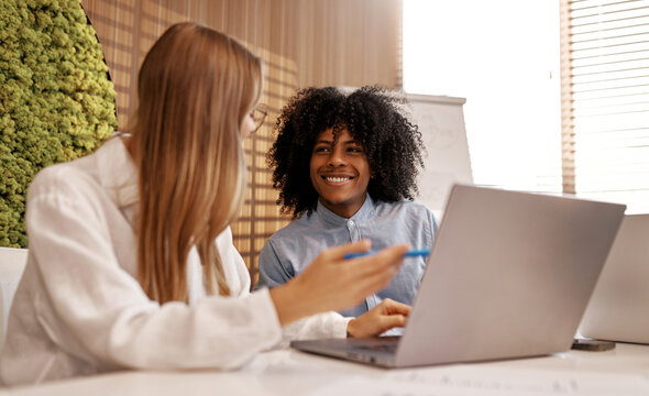 Team brainstorming with laptop in modern office