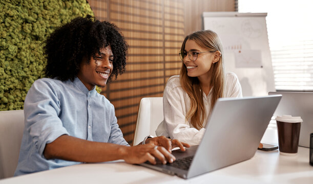 Team brainstorming with laptop in modern office