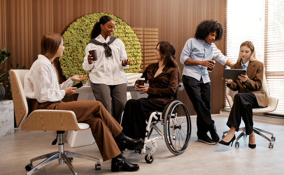 Diverse team having coffee break in modern office