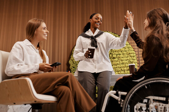 Team diversity and inclusion concept, women celebrating success at modern office