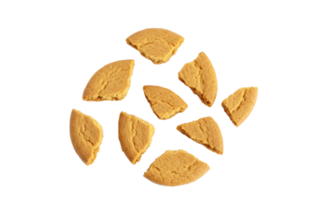 Golden-brown cookie crumbs and dusty particles dynamically scattered on an immaculate transparent background with soft shadows, macro flat lay, concept of baking ingredient texture.