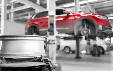 Red suv in auto repair shop with focus on car wheel rim