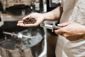 Close-up of coffee roasting process with freshly roasted beans in professional roastery setting