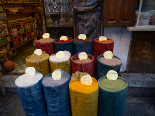 Colorful Moroccan spices displayed in a street stall in the Medina of Fez, showcasing vibrant textures and traditional market culture.