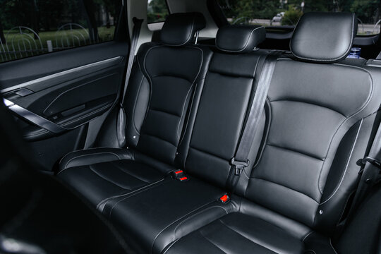 Spacious black leather rear seats in a modern SUV, featuring headrests, seatbelts
