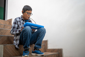 Boy practicing melodica with a hearing aid, learning music at home
