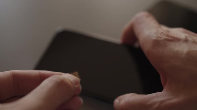 Male hands manipulating sim card for insertion into modern smartphone, representing phone setup, mobile communication, new technology integration, closeup. Shooting in slow motion.